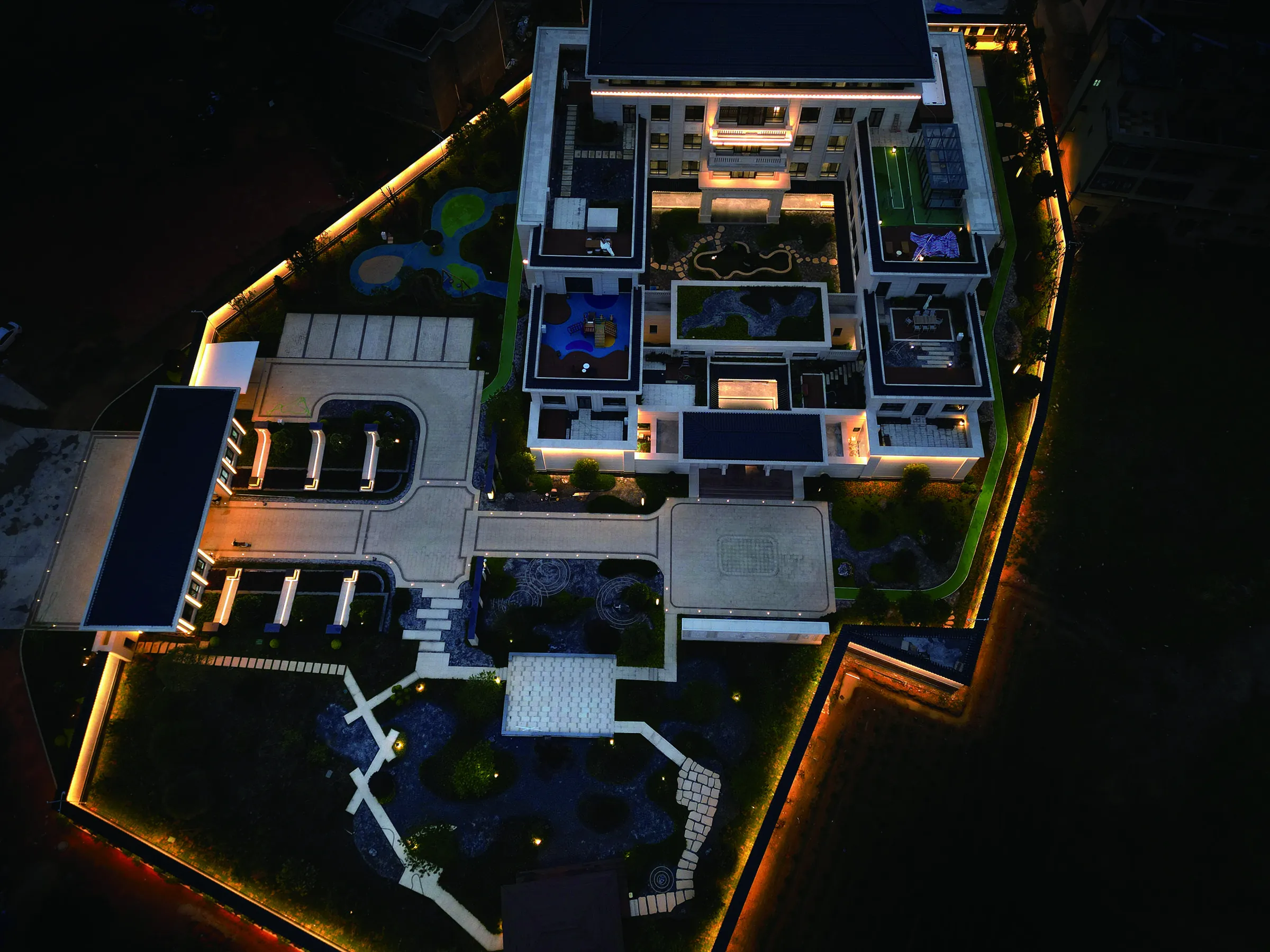 A residence seen from directly above at night, showing the courtyards, garden, water features, terraces and how the functional zones relate